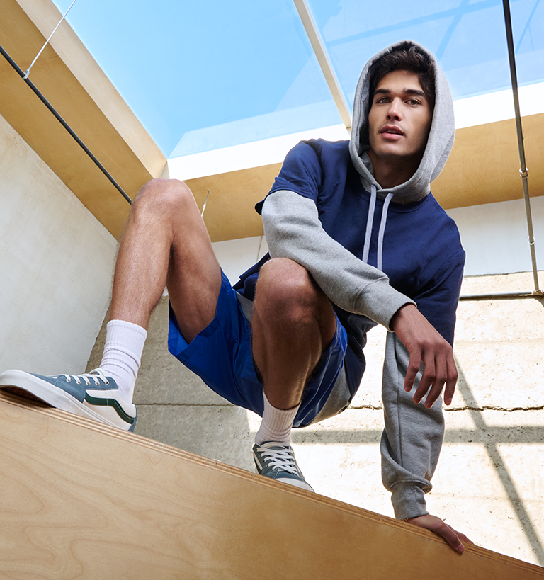 Male model gray hoodie with a blue tee and shorts. 