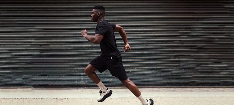 Male model wearing black dri-power t-shirt and black shorts running Male model wearing black dri-power t-shirt and black shorts running
