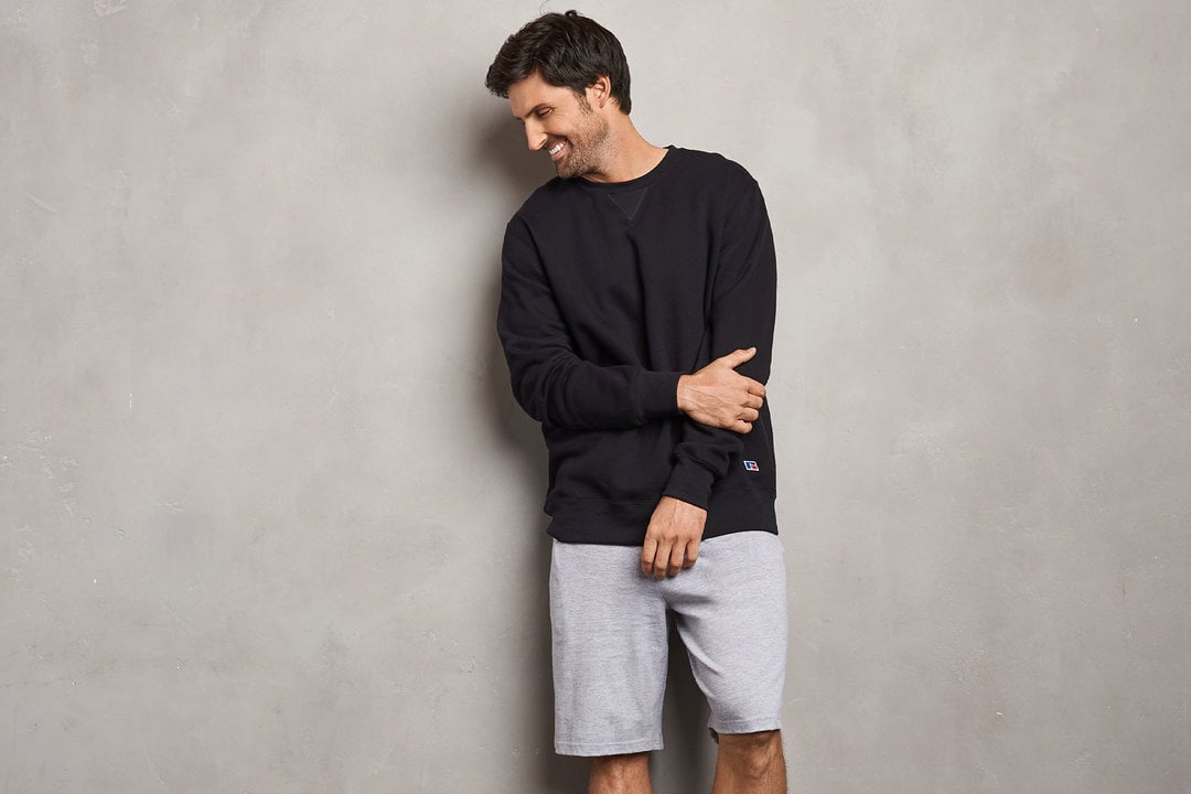 Man wearing Russell Athletic sweatshirt with shorts.