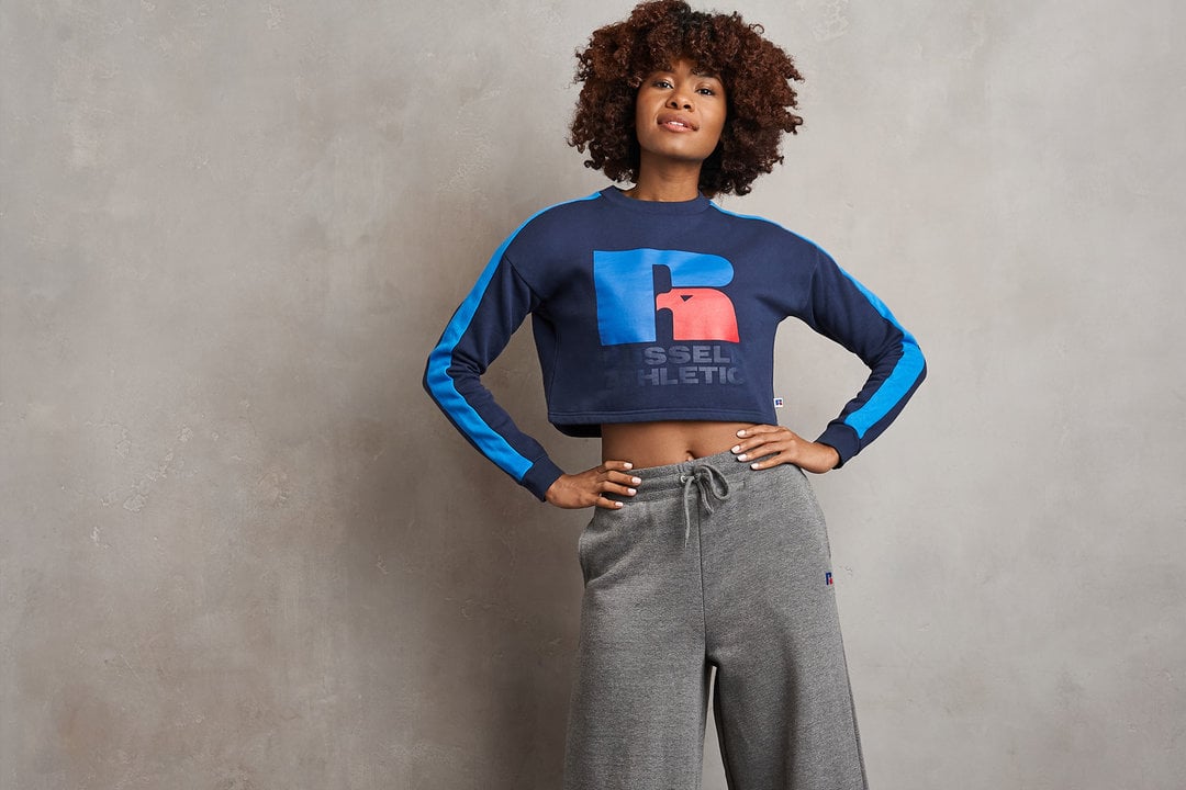 Woman posing wearing Russell Athletic sweatshirt.