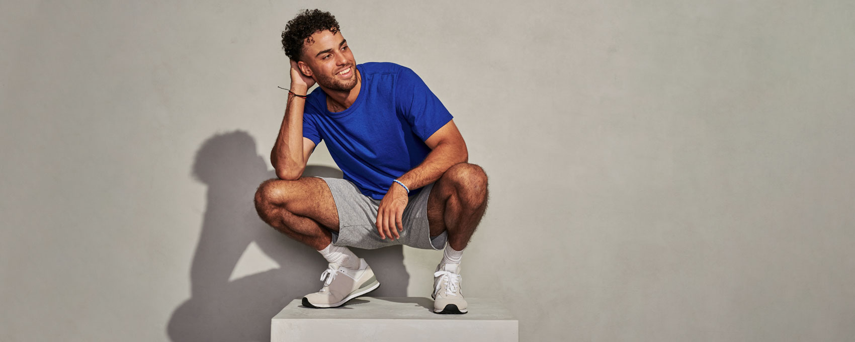 Male Model wearing blue Russell Athletic Tee and Gray shorts.