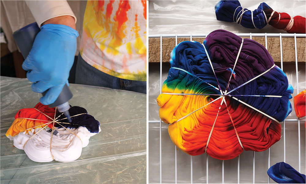 Various colors of tye die being applied to the folded rubber-banded tshirt.