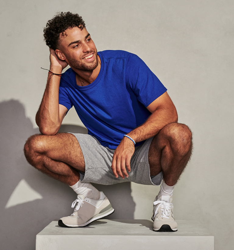 Male Model wearing blue Russell Athletic Tee and Gray shorts.